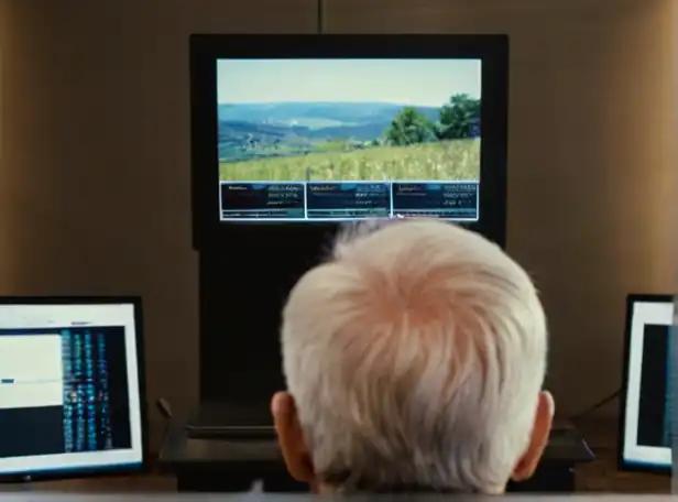 A person sitting in front of a computer with pension simulator screens