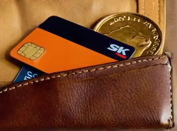 Credit card and coins in a wallet with shopping bags