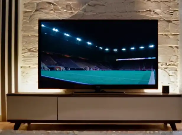 A person sitting in front of a TV with a console