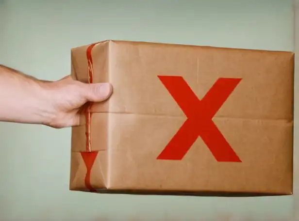 Disappointed person holding an Amazon package with a red X