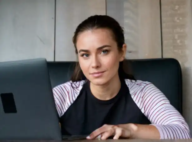 A person in front of a laptop with a relaxed expression