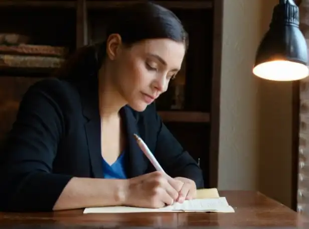 A person sitting at a desk writing letter