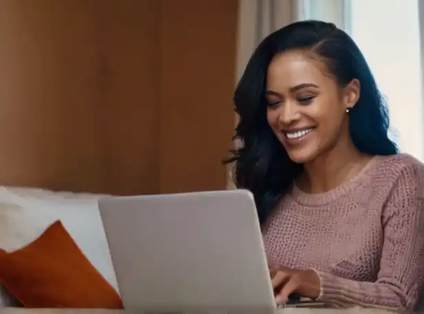 Woman smiling surrounded by organized emails on a laptop