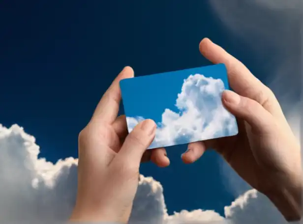 A hand holding a small card computer backed by digital clouds
