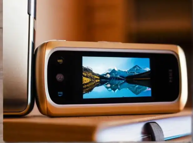 Smartphones stacked with printed photos on a desk