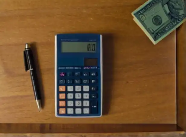 A calculator on a desk with currency notes and papers