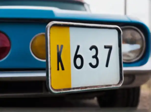 A close-up of a car license plate with a magnifying glass