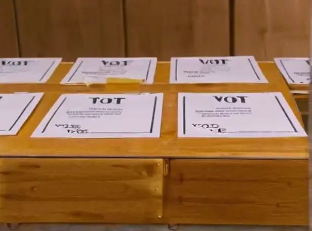 voting ballots on a table surrounded by question marks