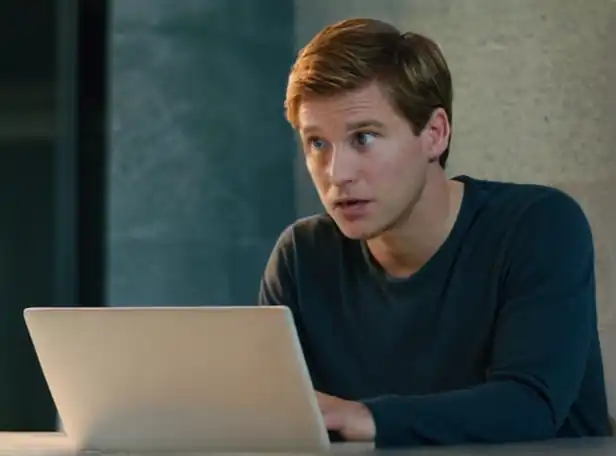 A person looking at a computer screen or a paper with a confused expression
