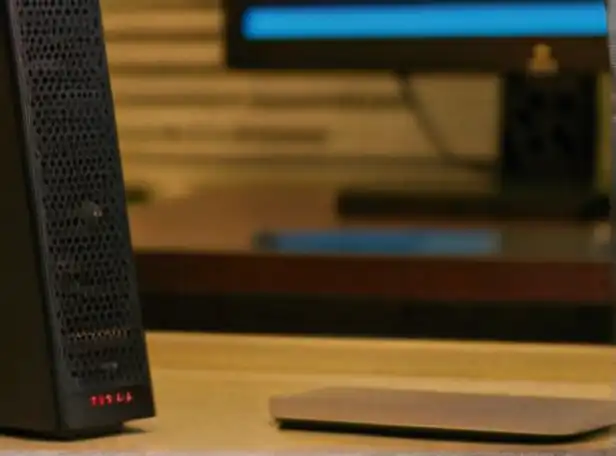 A person in front of a computer with a wireless router