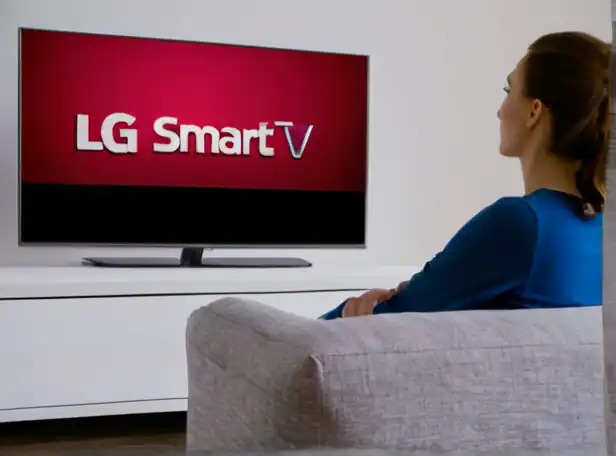 A person sitting on a couch watching a smart TV with LG logo