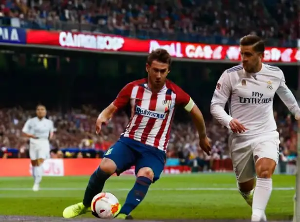 Atlético de Madrid and Real Madrid football players in intense match action