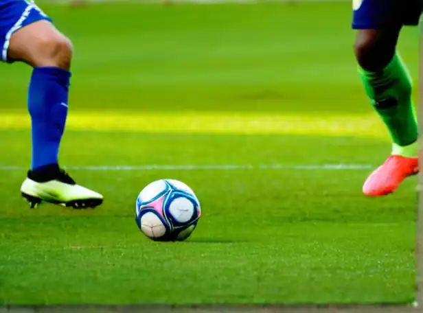 Futbol players on a green pitch in intense competition