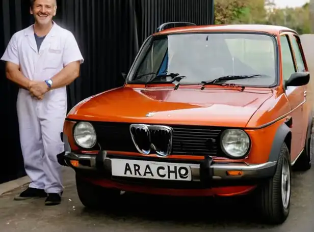 Car owner standing next to a sold car with a smiling mechanic