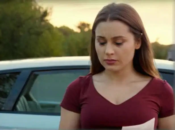 Car owner holding receipt with puzzled expression