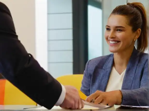 Car owner hands paperwork to a smiling official