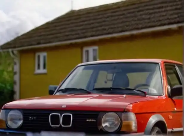 Car being sold outdoors with a tax inspector in the background