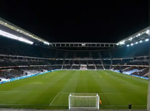 European football stadium under bright lights at night