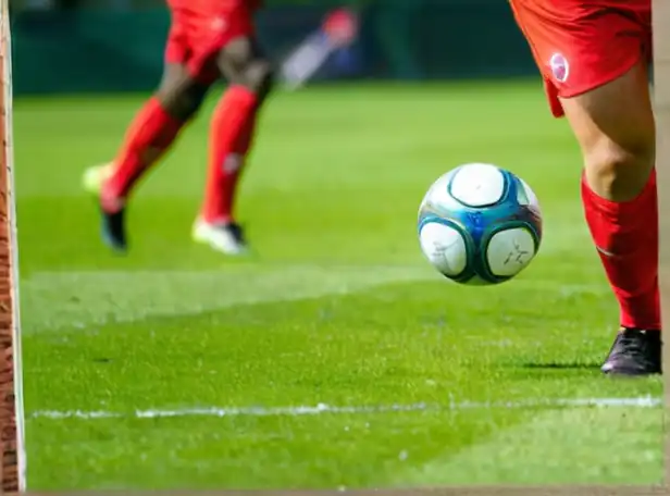 Soccer players in action on a green grass pitch