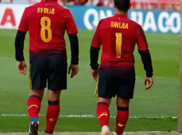 Spanish national soccer team players walking away from a stadium