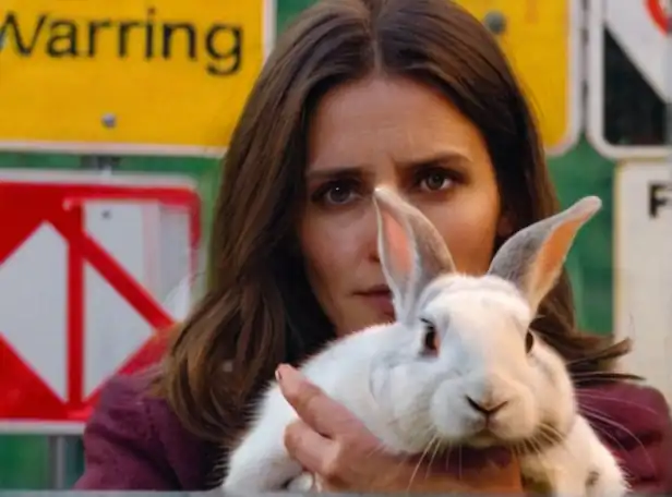 A concerned woman holding a pet rabbit surrounded by warning signs