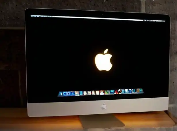 Dark screen and lit up Apple logo on a iMac desktop