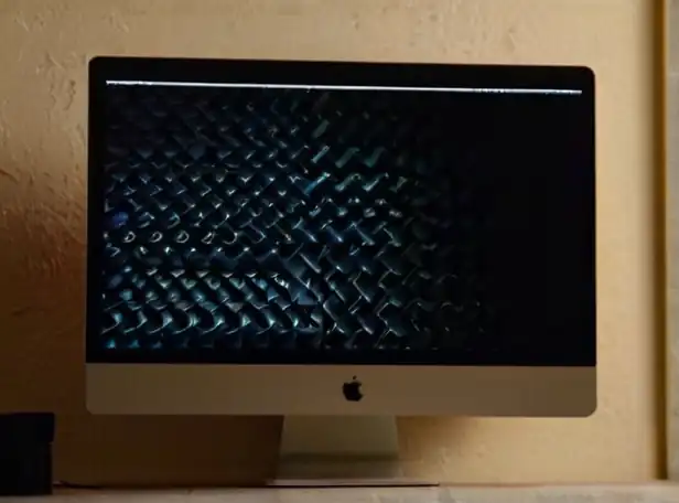 Dark screen Mac computer with puzzled user looking on