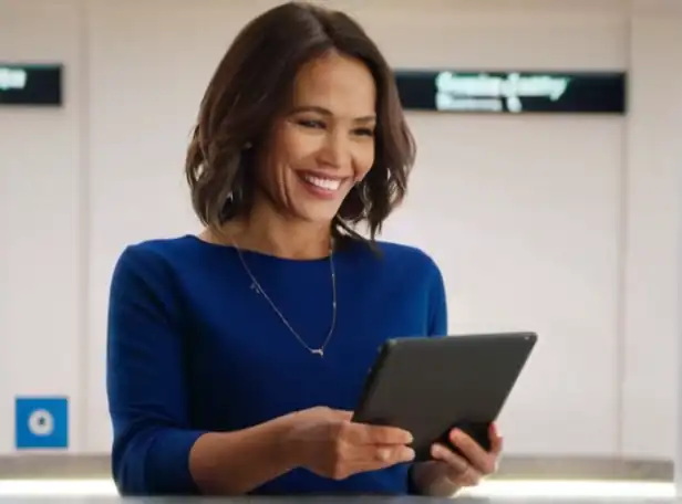 Woman holding a tablet with a smile looking at a social security number screen