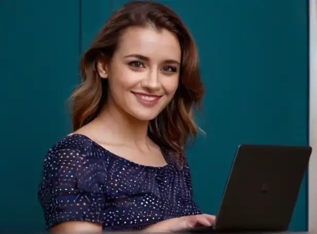 A person holding a laptop with a pleased expression