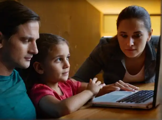 Family sitting in front of computer browsing book online