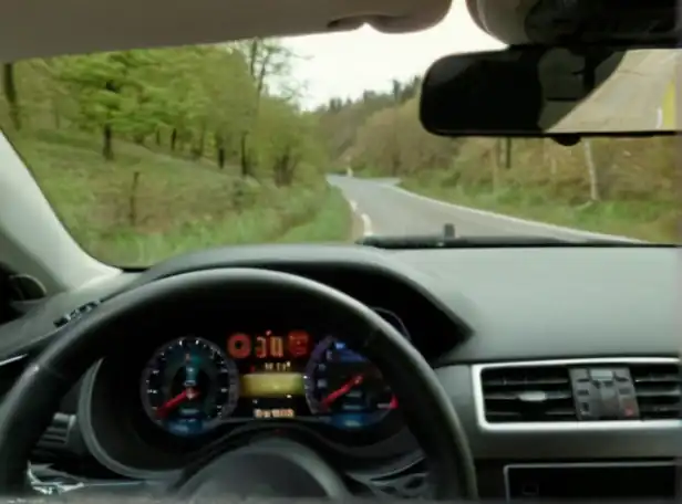 A person driving a car with a road map and clock