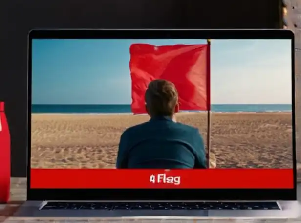 Cautioned consumer sitting in front of a laptop with a red flag