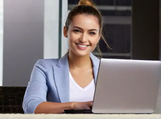 Young professional smiling with laptop on a modern background