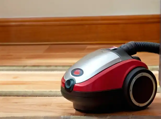 Vacuum cleaner on floor with suction power gauge in focus