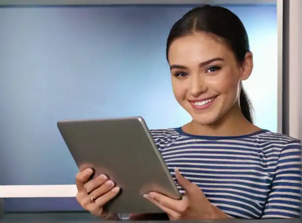 A person holding a tablet or laptop with a smile