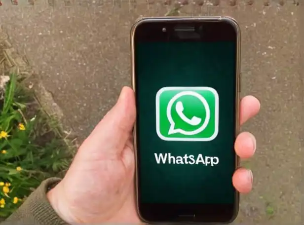 A person looking at a smartphone with WhatsApp open