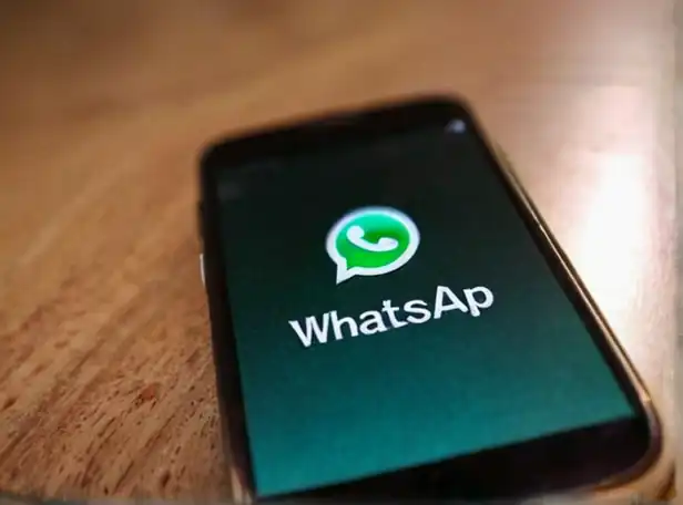 A person's phone with WhatsApp open showing various status updates