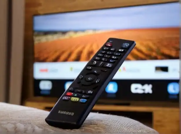 Smart TV remote control and Samsung logo on a couch